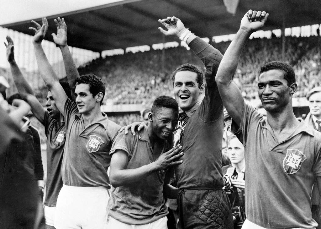 Brazil's 17- year-old star Pele, center, weeps on the shoulder of goalkeeper Gilmar Dos Santos Neves after Brazil's 5-2 victory over Sweden in the final of the World Cup tournament in Stockholm. (l-r) Garrincha, Orlando, Pele, Gilmar and Didi.